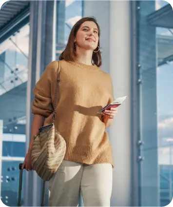 Woman at an airport holding a passport and boarding pass